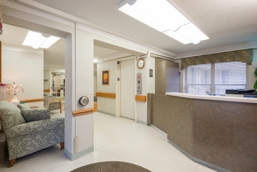 A bright and welcoming hospital reception area with comfortable seating and an elevator.