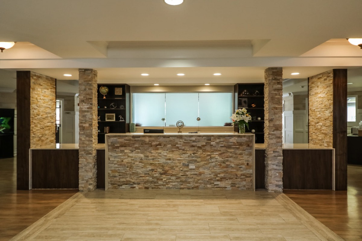 A modern kitchen featuring a stone backsplash, pendant lighting, and a spacious kitchen island with wood flooring.