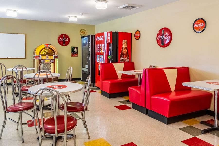 A retro-themed diner with red booths, Coca-Cola decorations, and a vintage jukebox.