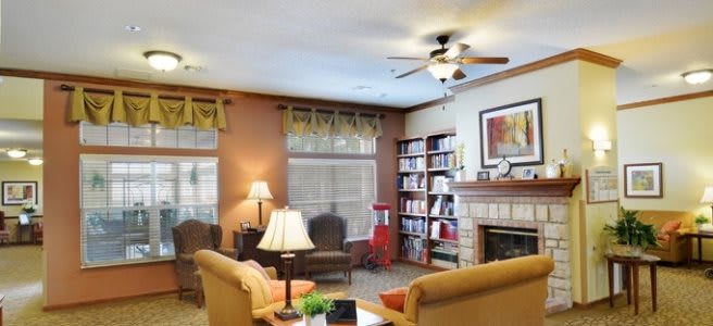 A cozy living room with comfortable seating, a bookshelf, and a fireplace.