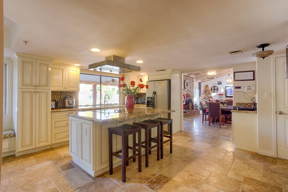 A spacious and modern open-plan kitchen with an island and bar stools.