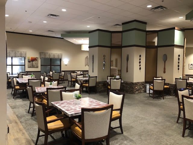 An empty restaurant dining area with neatly arranged tables and chairs.