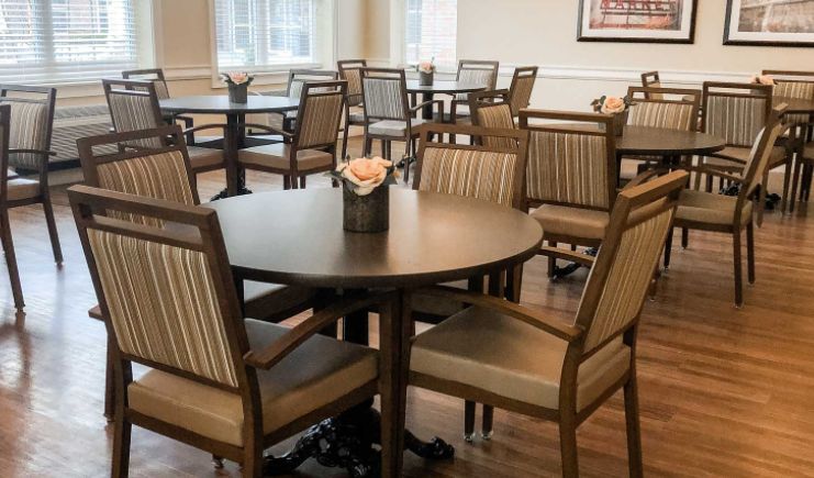 A cozy indoor dining area with round tables and upholstered chairs.