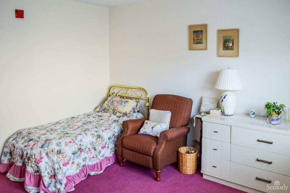 Cozy bedroom with a single bed, armchair, and dresser.