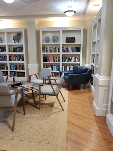A cozy reading nook featuring comfortable chairs and bookshelves filled with books.