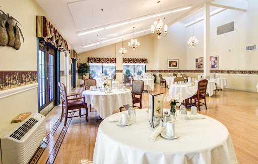 An elegant dining area featuring well-set tables, inviting natural light, and a warm ambiance.