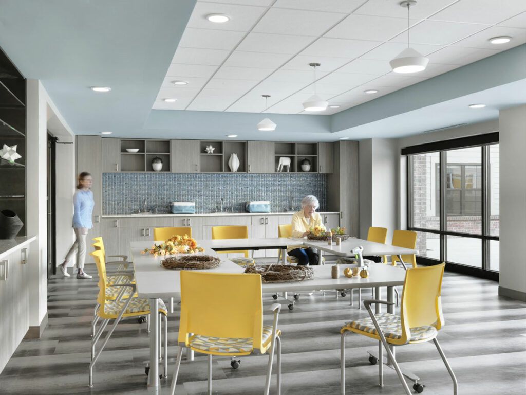 A modern kitchen and dining area featuring sleek design elements and vibrant yellow chairs.