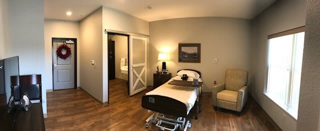 A well-furnished hospital room featuring a bed and cozy amenities.
