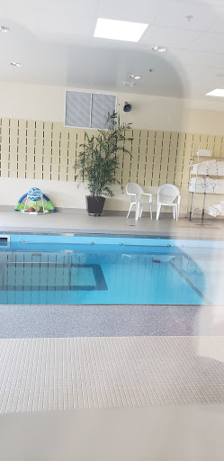 A serene indoor swimming pool area with comfortable seating and greenery.