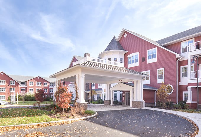 A picturesque residential building with a welcoming entrance and vibrant red exterior under a clear blue sky.