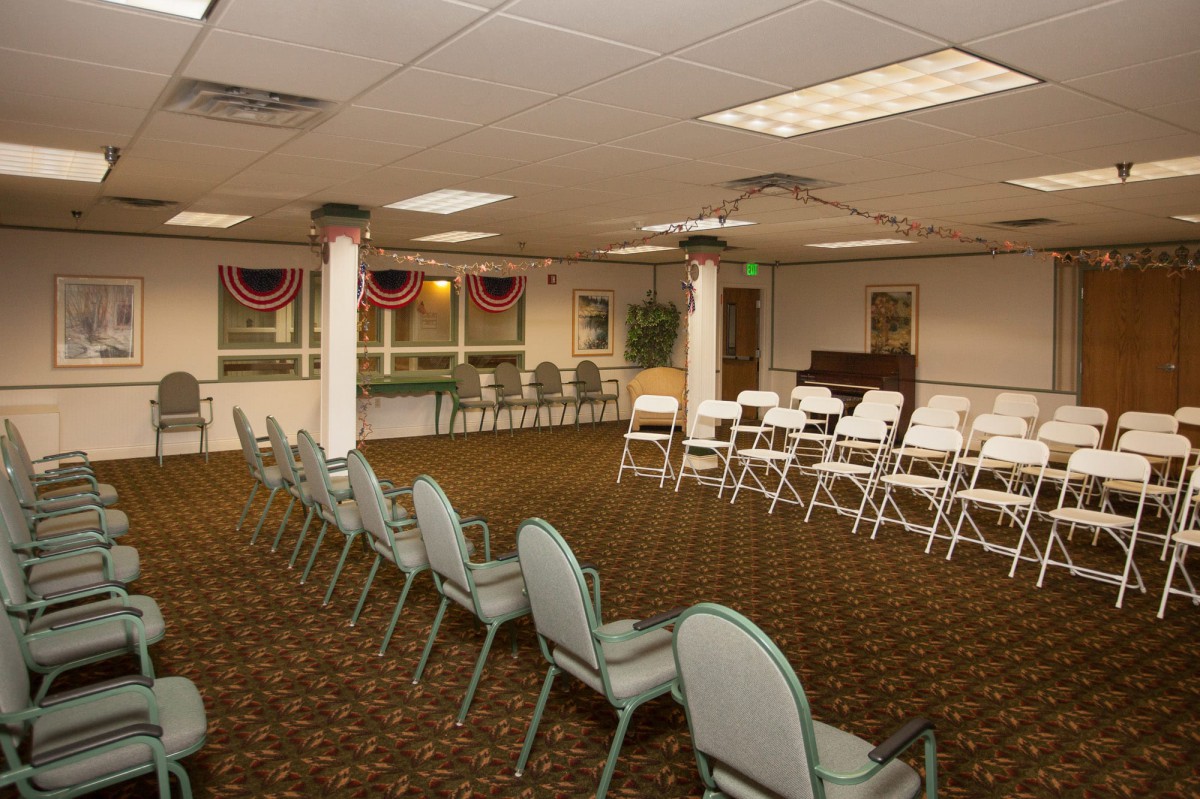 An empty conference room with arranged chairs and a carpeted floor, ready for a meeting.