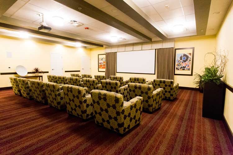 A cozy home theater room with a large screen and comfortable seating.