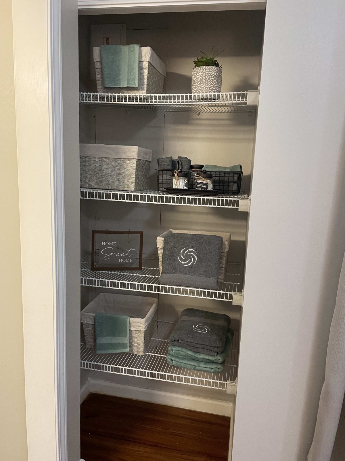 A neatly organized closet with shelves filled with storage baskets and home decor items.
