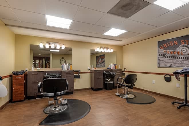 Interior view of a hair salon with two styling chairs and mirrors.