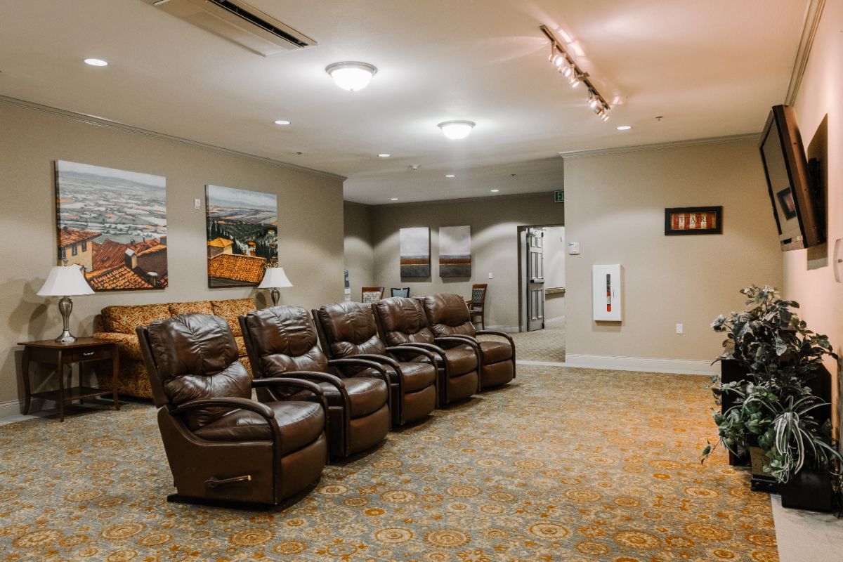 A comfortable lounge area with multiple recliners and wall art under soft lighting.