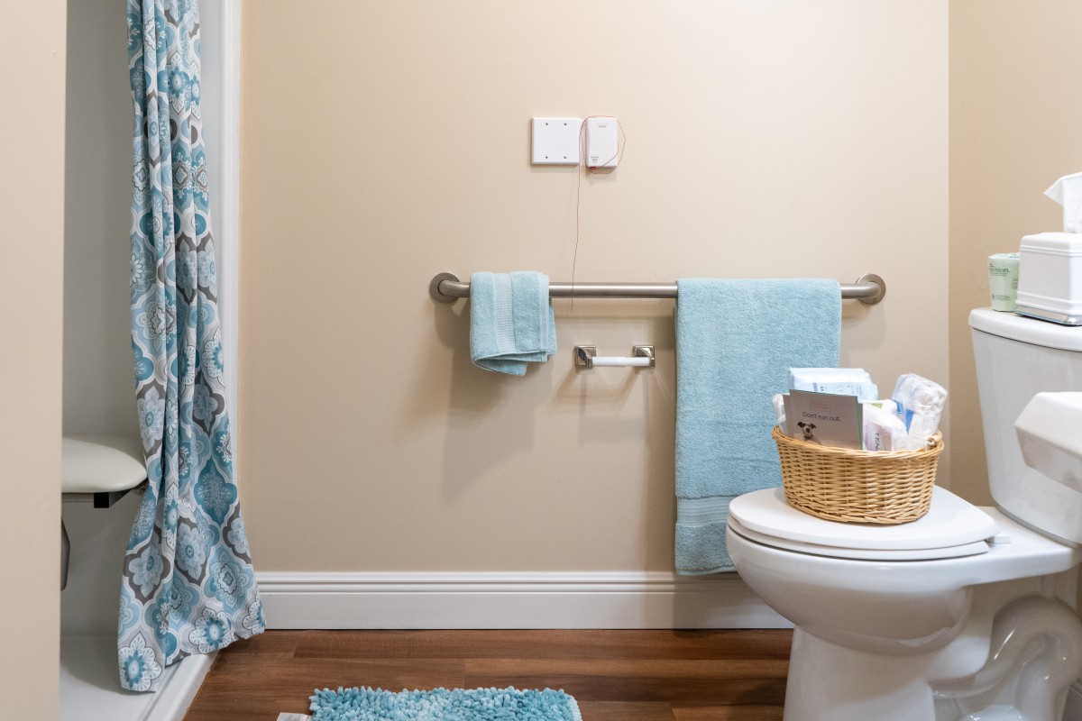 A neatly arranged bathroom with blue towels and a shower curtain.