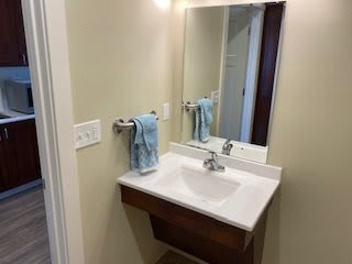 A clean and simple bathroom sink area with a mirror and towel.