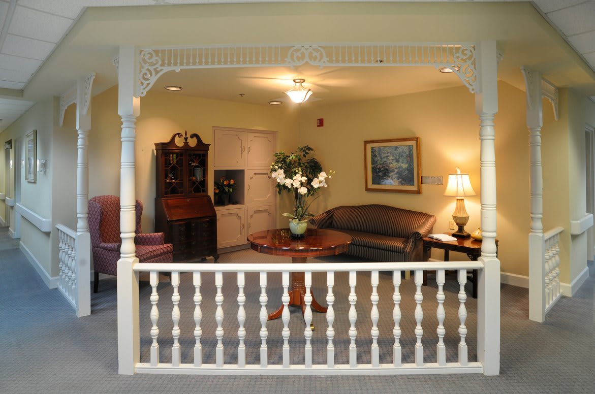 A cozy living room setup featuring a sofa, coffee table with floral centerpiece, and ambient lighting.