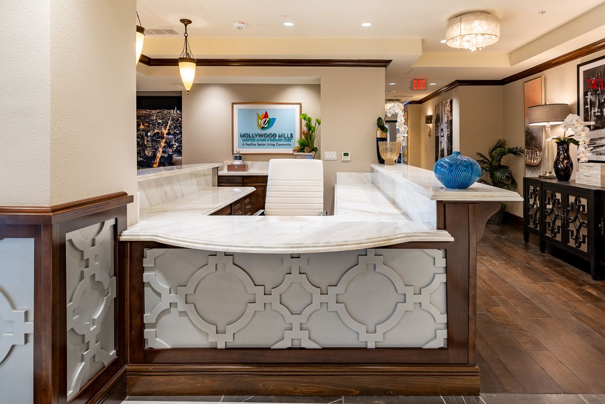 A well-designed office reception area with a central desk, elegant lighting, and modern decor.