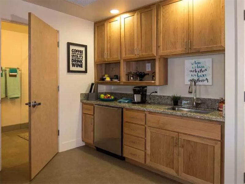 A modern kitchen featuring wooden cabinets and a granite countertop.