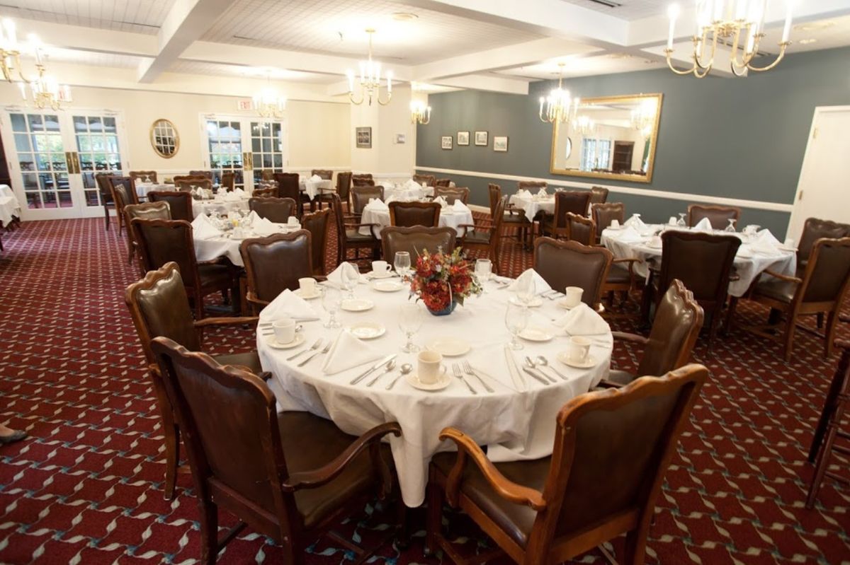 A formal dining room with elegantly set tables, ready for an event.