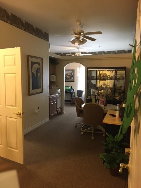 A cozy office space with furniture, plants, and artwork.