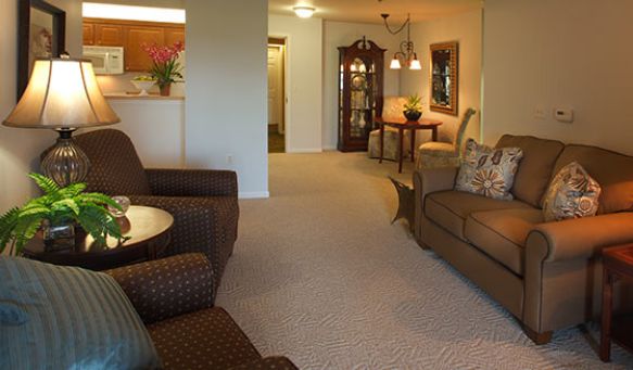 A cozy living room with comfortable seating and a dining area in the background.