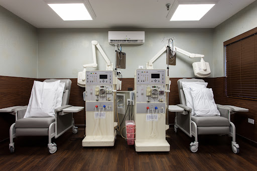 A treatment area in a healthcare facility with two dialysis machines and patient beds.