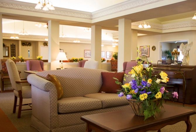 A cozy living room with a sofa and floral arrangement.