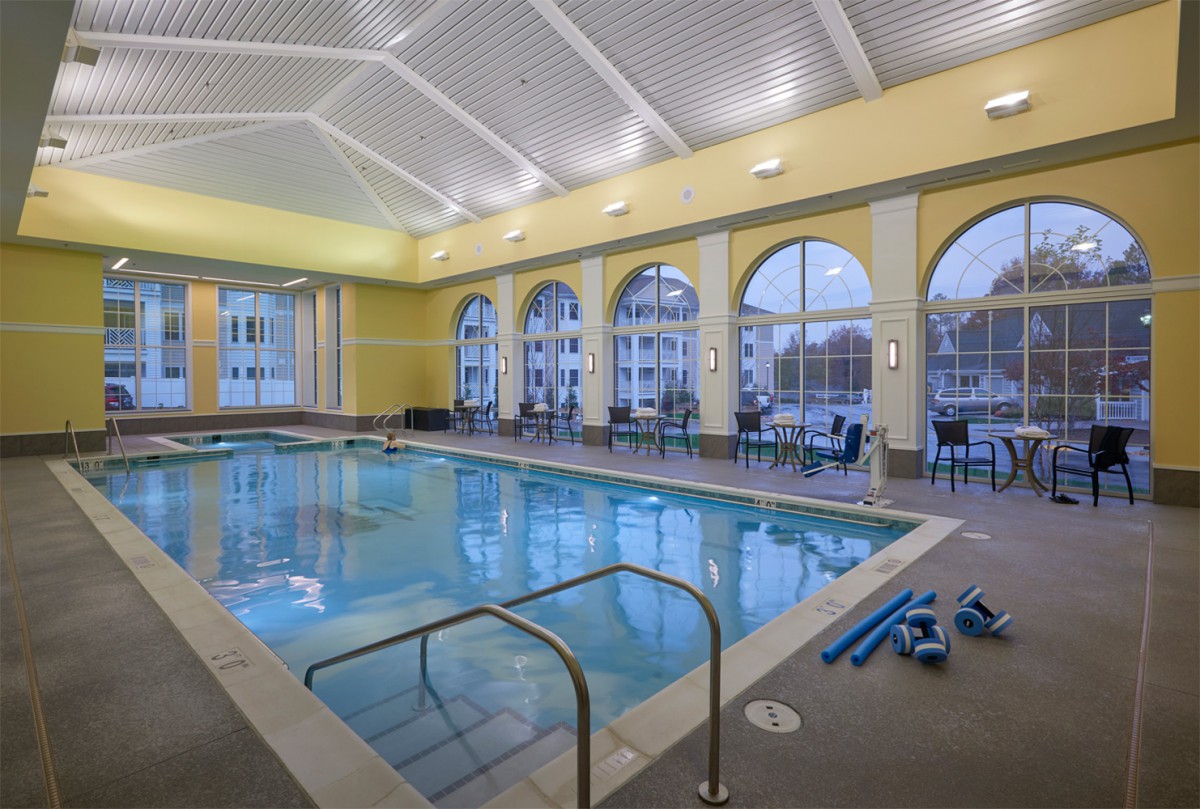 An indoor swimming pool with large windows and a spacious interior, designed for relaxation and fitness.