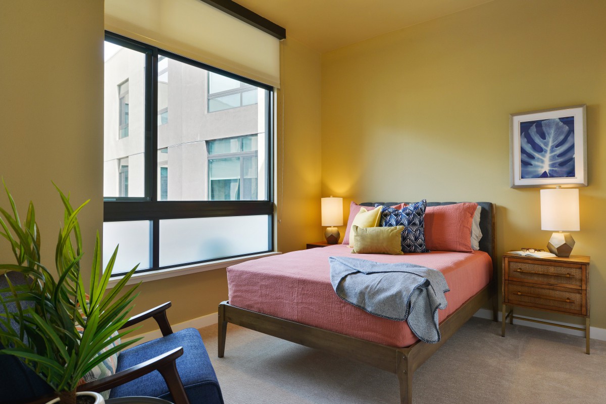 A modern bedroom with a large window and stylish furnishings.