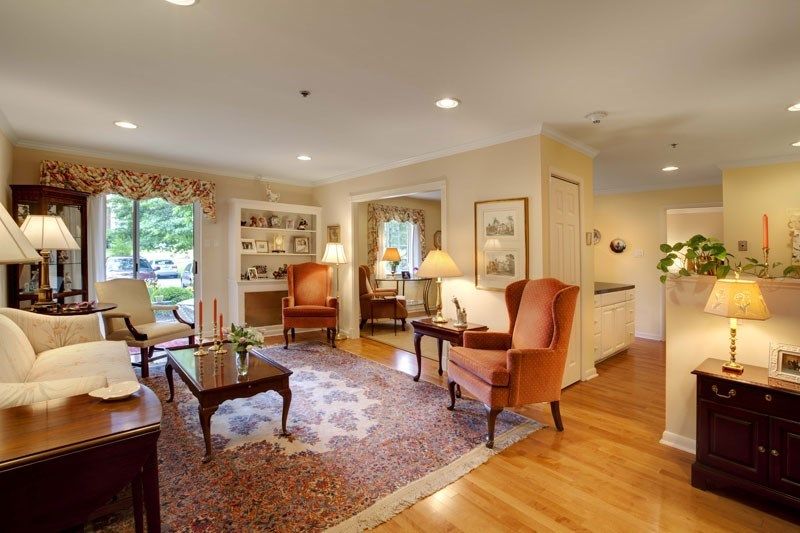 A cozy and traditionally decorated living room with comfortable armchairs, a coffee table, and soft lighting.