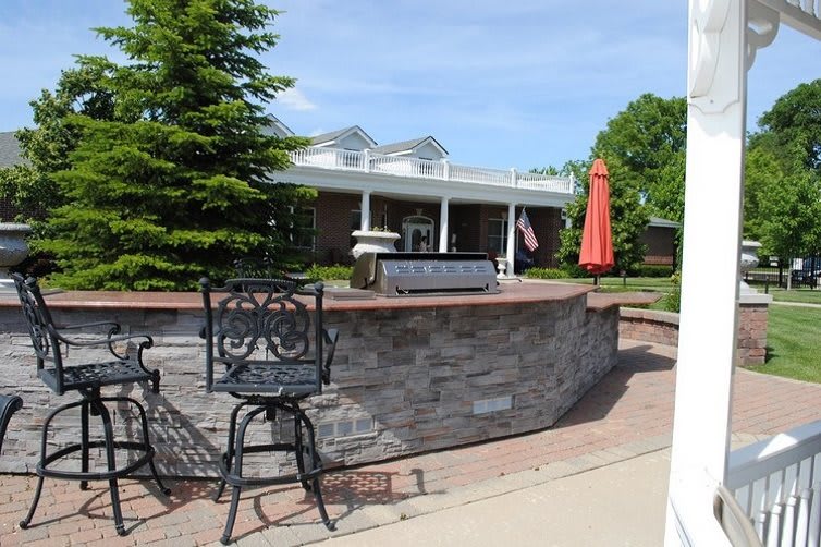 A patio with seating and an umbrella in front of a building on a sunny day.