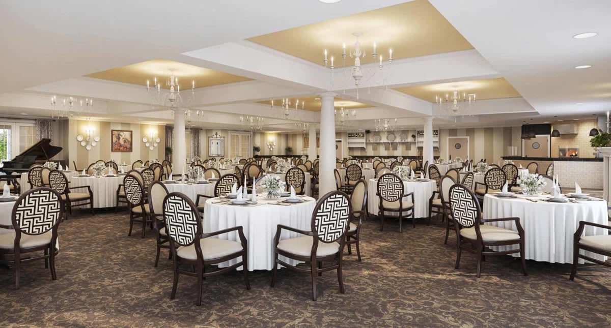 An elegantly decorated banquet hall with round tables and chandeliers.