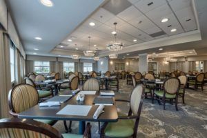 A spacious and elegantly decorated dining room with neatly arranged tables and chairs.