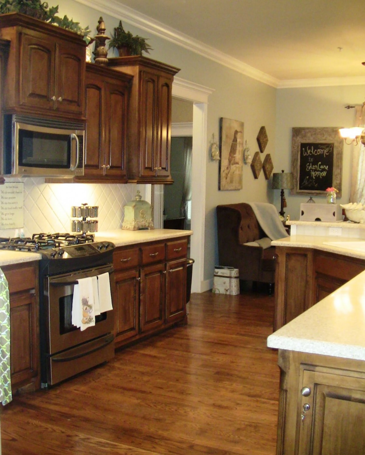 A cozy kitchen with wooden cabinets, featuring a stove and microwave.