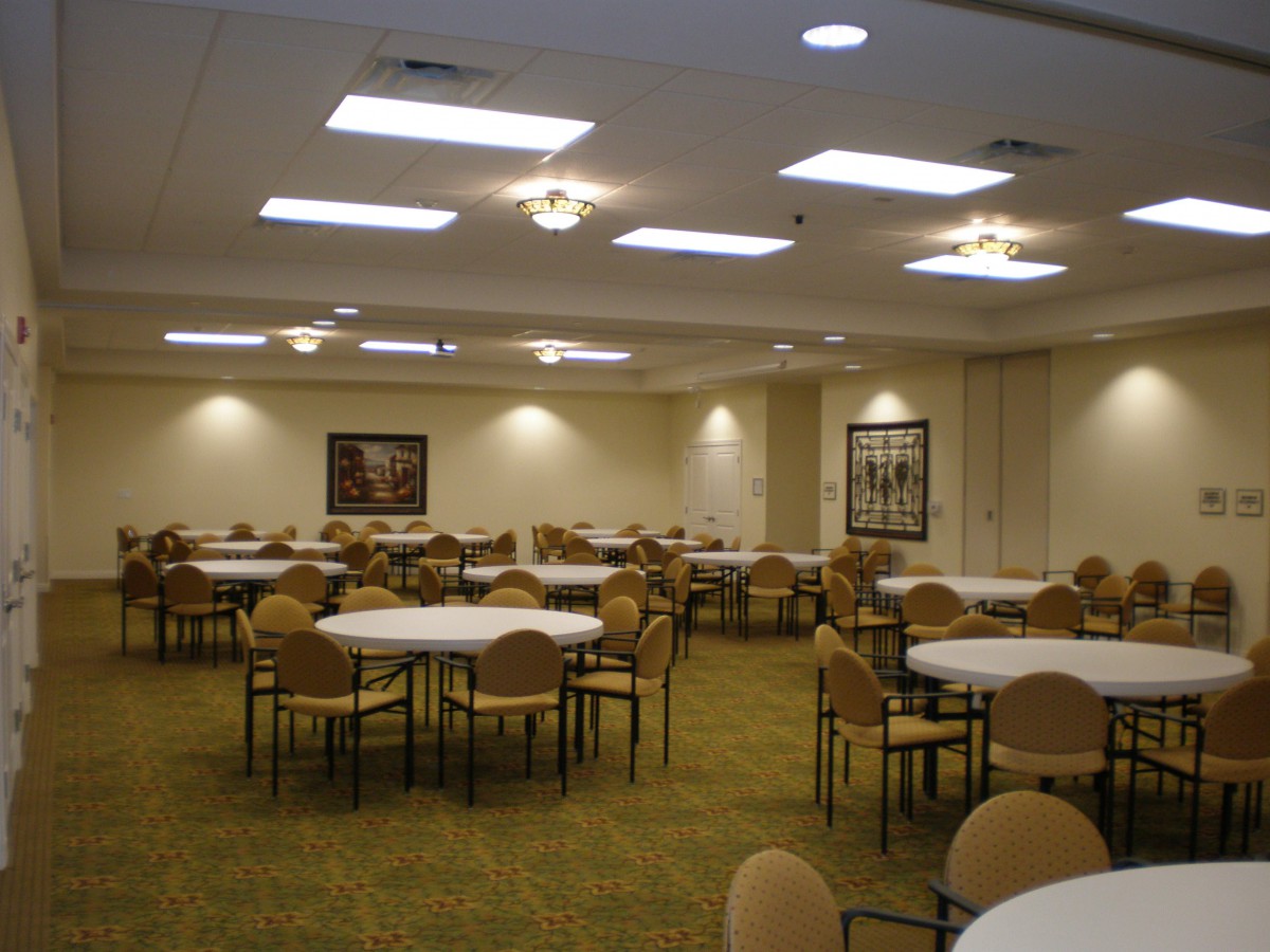 An empty banquet hall set up with round tables and chairs, ready for an event.