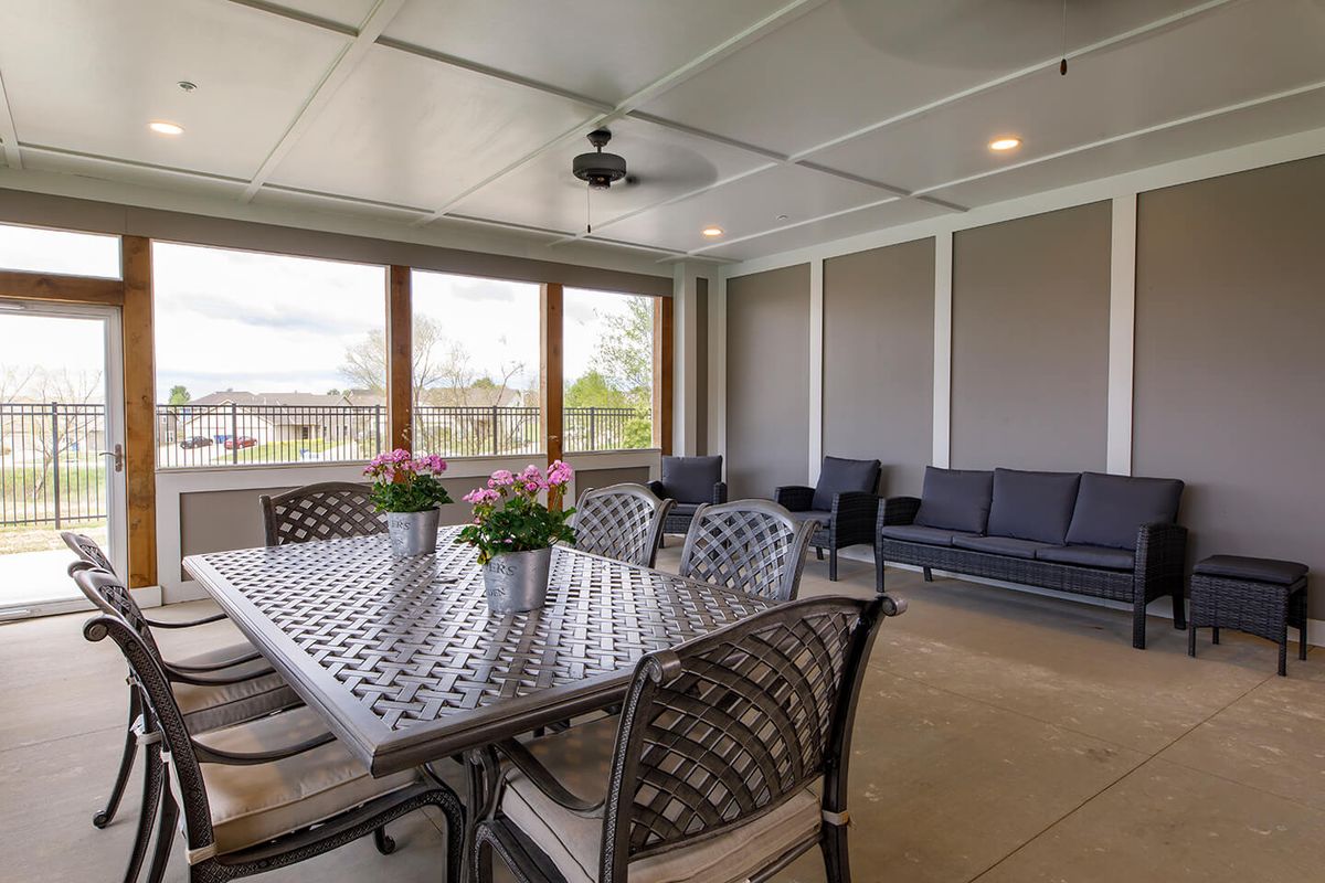 A cozy patio area with a dining table, chairs, and comfortable seating arrangements.