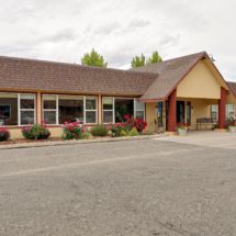 An exterior view of a building with a prominent entrance and surrounding landscape.