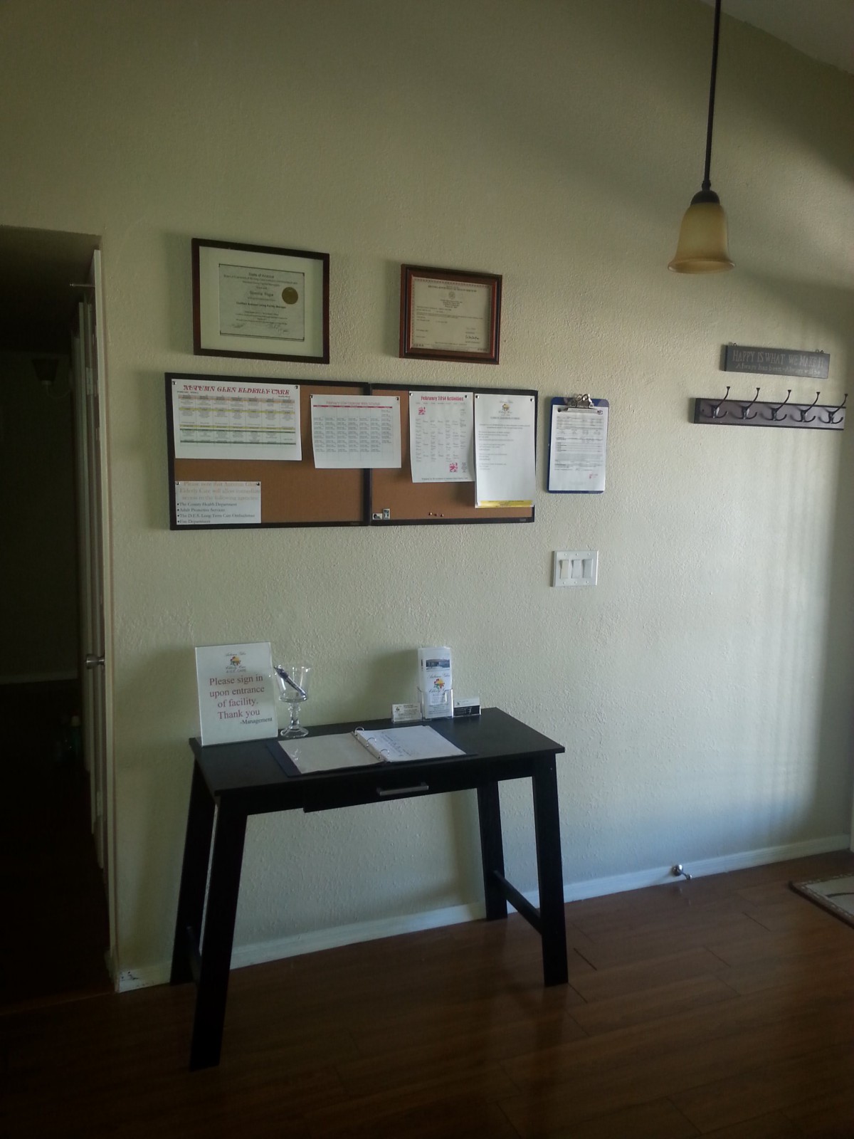 A tidy office corner featuring a desk and wall-mounted certificates.