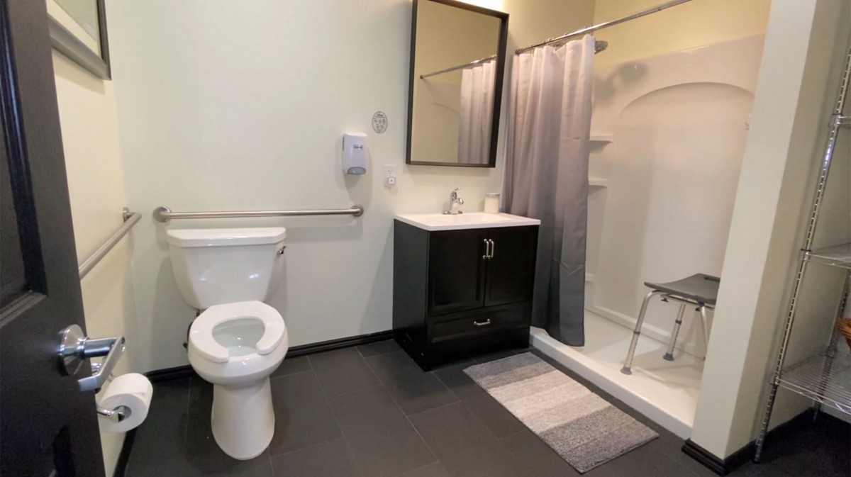 A modern bathroom with a toilet, sink, and shower area.