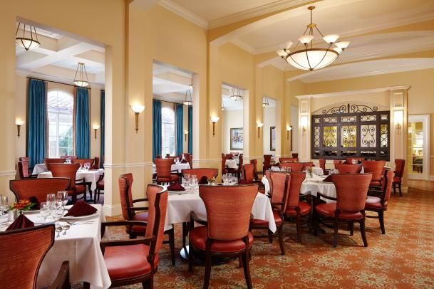 An elegant restaurant dining area with neatly arranged tables and plush chairs.