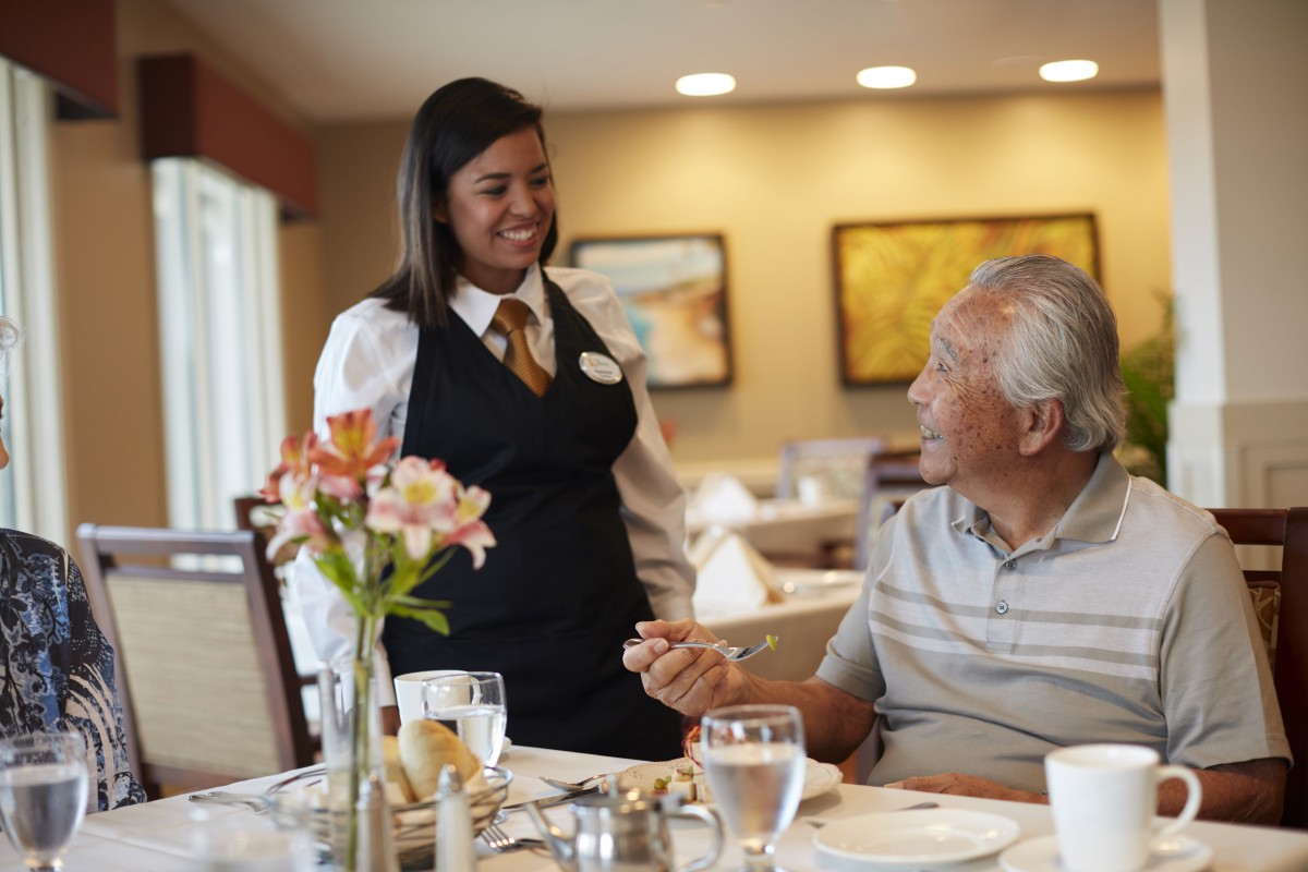 A waitress interacting with a customer in a restaurant setting.