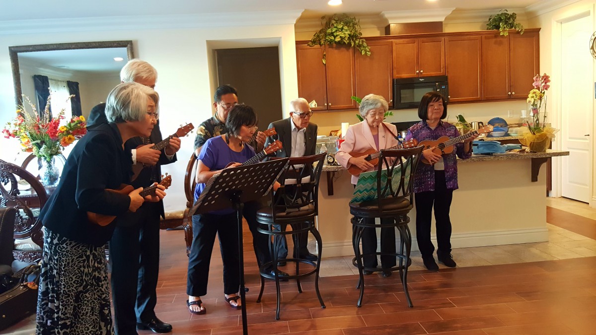 A group of seniors playing ukuleles in a cozy indoor setting.