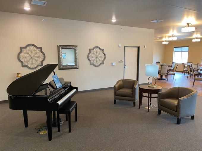 A modern lounge area with a grand piano and comfortable seating.