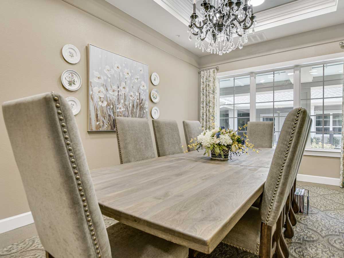 A beautifully decorated dining room with a wooden table, elegant chairs, and a chandelier.