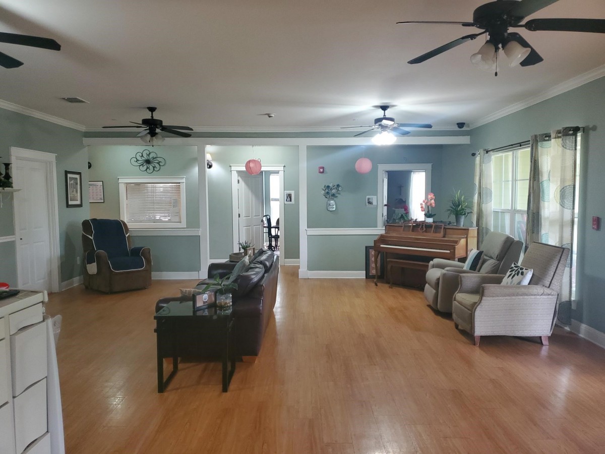 Spacious living room with seating area and wooden floors.