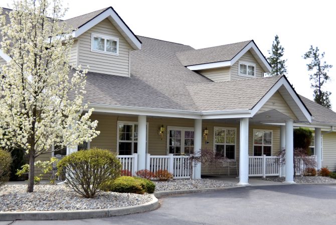 A suburban house with a porch and landscaped front yard.