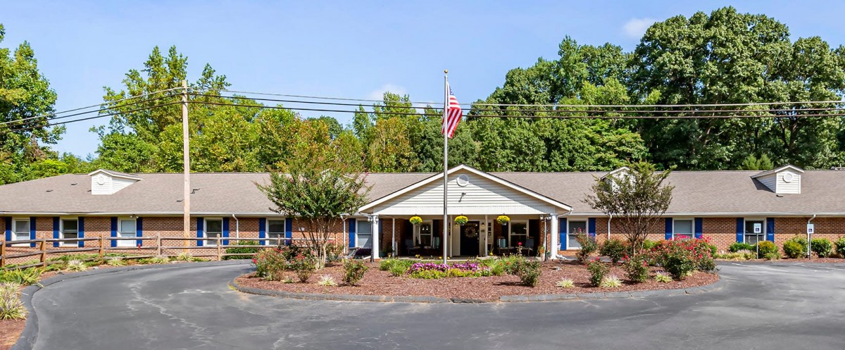 A single-story building with a landscaped front and an American flag flying overhead.