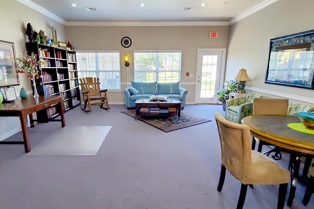 A cozy living room with comfortable seating, bookshelves, and plenty of natural light.